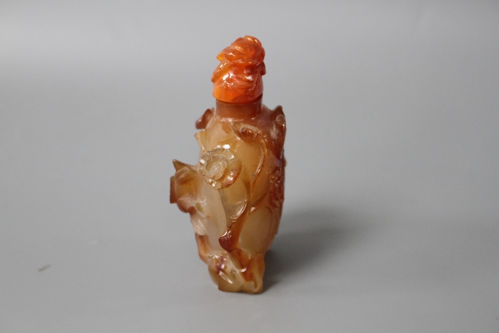 A Chinese orange agate snuff bottle and stopper, carved in relief with birds and flowers, width 6cm, height 8.5cm